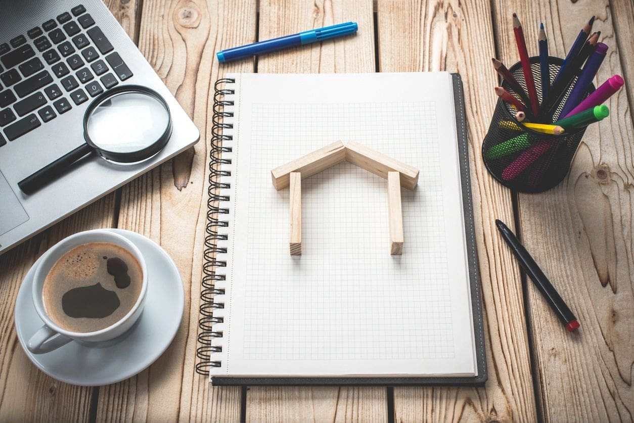 Wooden house model on notebook.