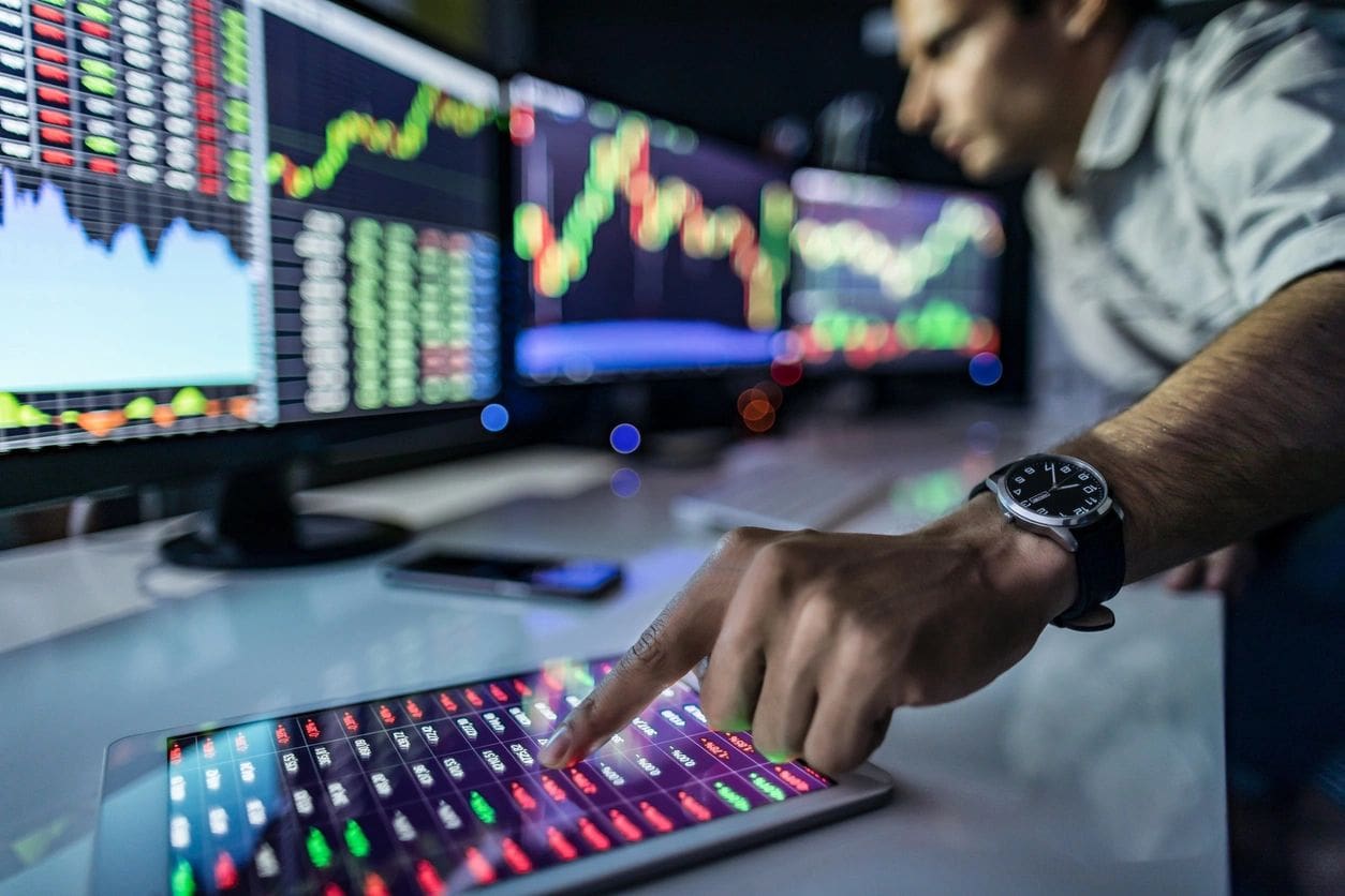 Man reviewing stock market data on tablet.