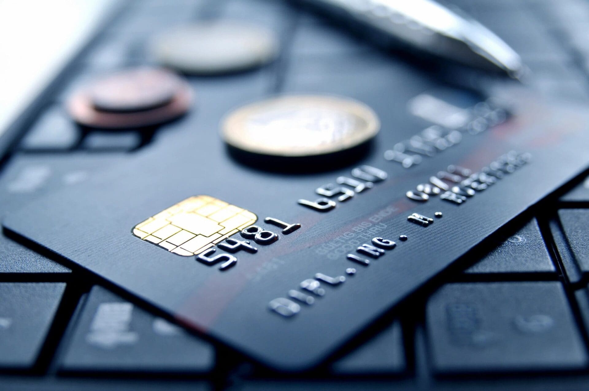 Credit card on keyboard with coins.